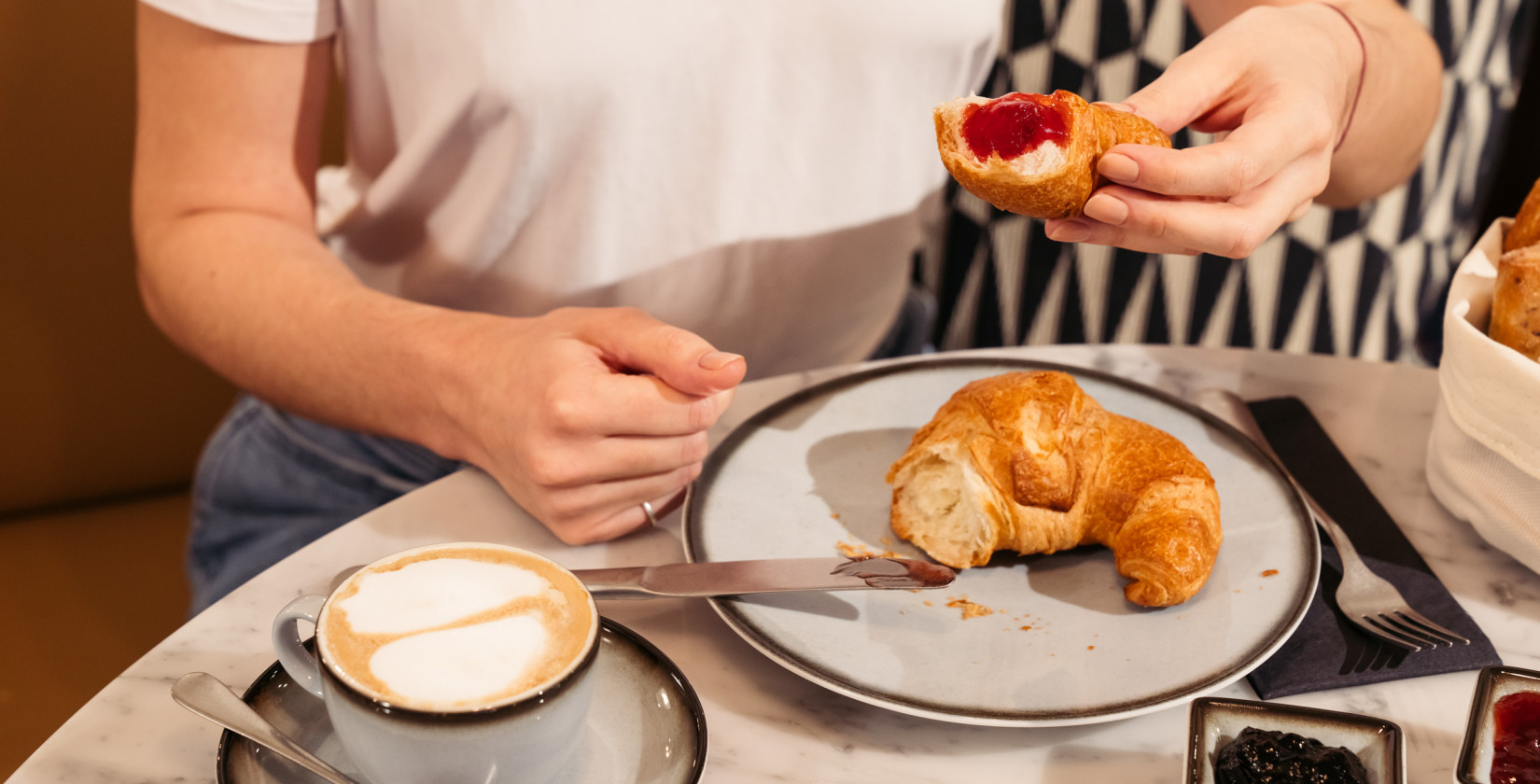 Eine Person mit einem Croissant in der Hand