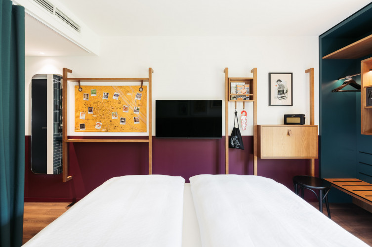 Der Blick von einem Doppelbett auf den Fernseher eines Hotelzimmers in Wien