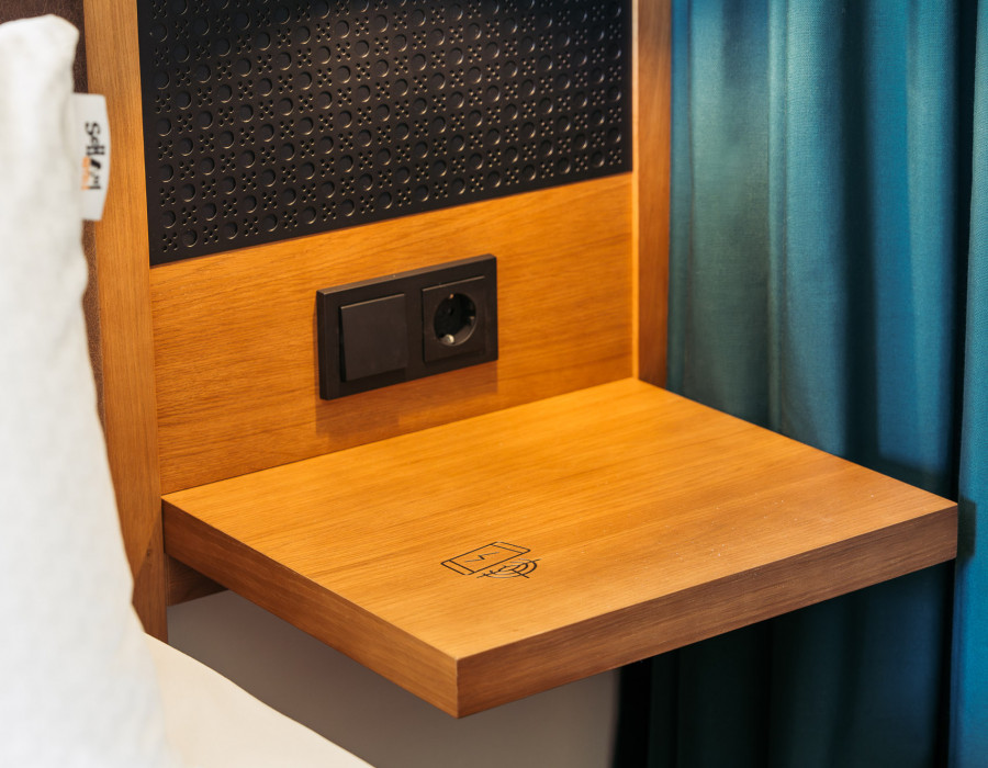 Wireless smartphone charging station on a nightstand at Hotel Schani UNO City