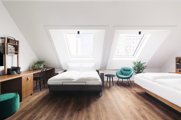 Ein Familienzimmer mit zwei Doppelbetten und Dachschräge im Hotel bei der UNO-City in Wien