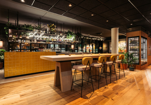 Bar mit langem Hochtisch und Stühlen im Hotel Schani UNO City Wien